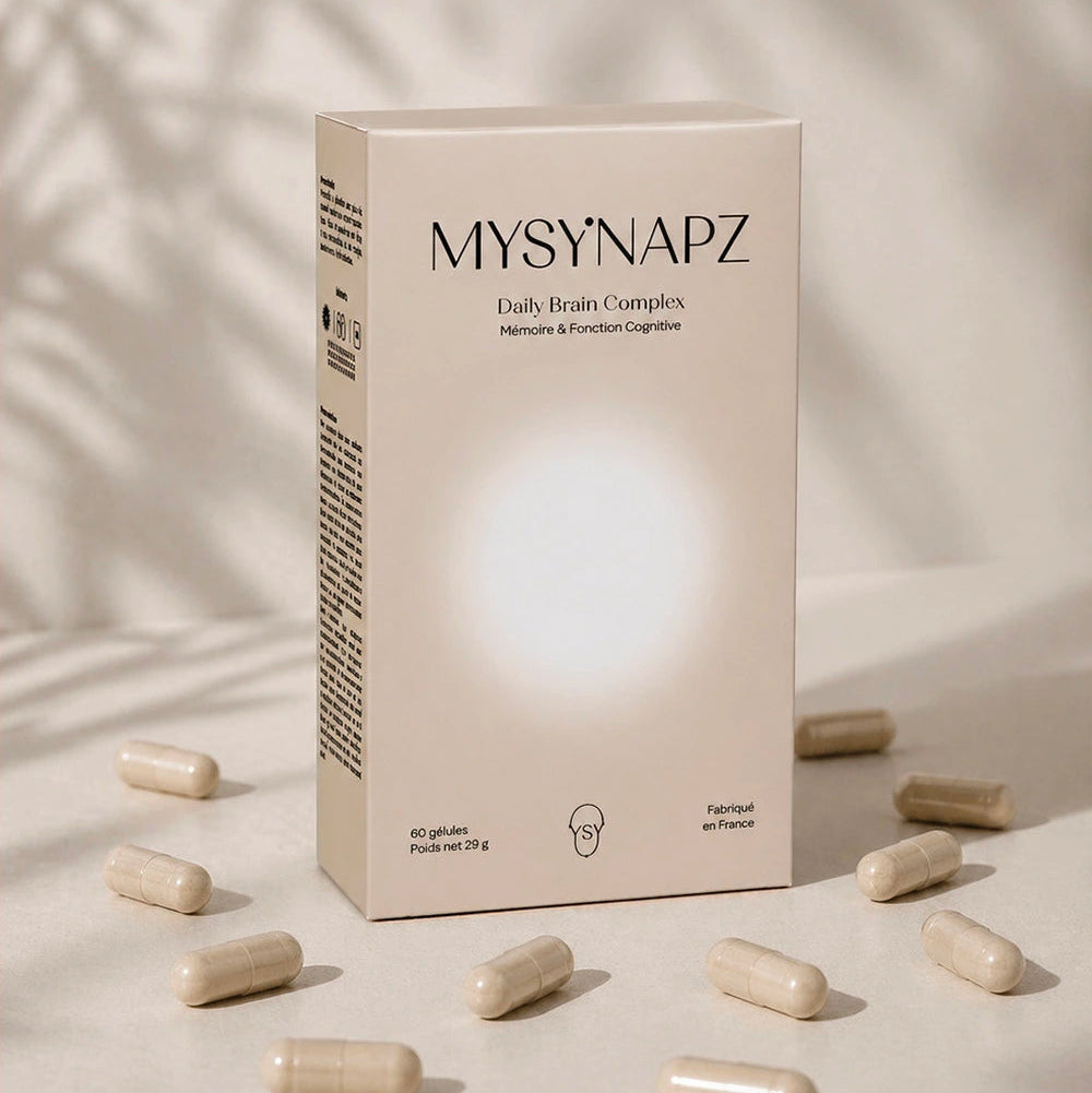 Boîte du complément alimentaire MySynapz Daily Brain Complex entourée de gélules sur fond beige